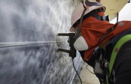 A male worker at high test steel tank butt weld  carbon shell plate of storage tank crude oil background white contrast of magnetic field test